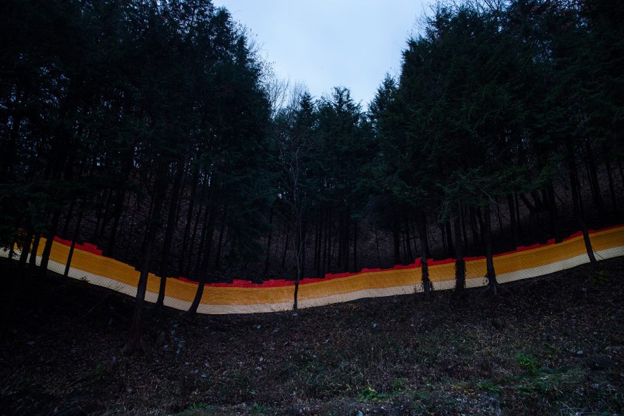 A special light painting technique reveals radioactive contamination in a forest bordering the Sato family house in Iitate. The forest has been decontaminated, but authorities only do 20 metres in from the edge, with everything beyond falling under the responsibility of a separate government agency. Forest beyond the 20 metre boundary is not decontaminated, leading to constant re-contamination of the lower forest and house that borders it. Here we see radiation levels between 0.97uSv/h and 1.4uSv/h, with yellow showing spots elevated above the government decontamination target of 0.23 uSv/h, and red showing above 1uSv/h.